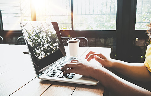 Zwei Hände tippen auf einem Laptop Zwei Hände tippen auf einem Laptop