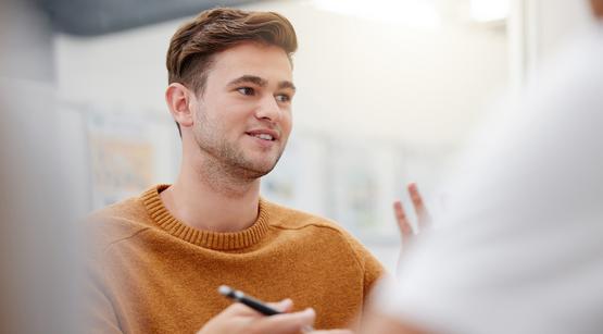 Referent gestikuliert vor Teilnehmenden.