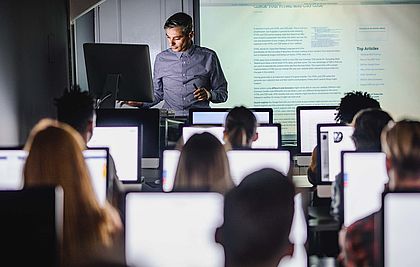 PC-Schulklasse mit Lehrer am Whiteboard