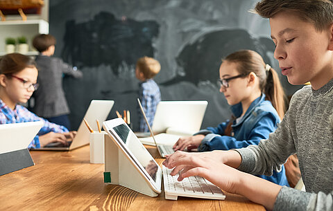 Schüler mit Tablets und Laptops Schüler mit Tablets und Laptops